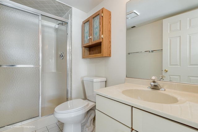 bathroom featuring tile patterned flooring, vanity, toilet, and walk in shower