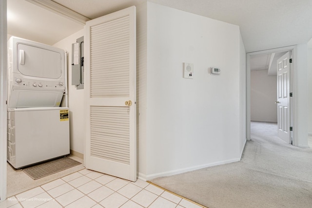 laundry area with electric panel, stacked washer and dryer, and light colored carpet