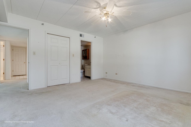 unfurnished bedroom featuring connected bathroom, ceiling fan, and light carpet