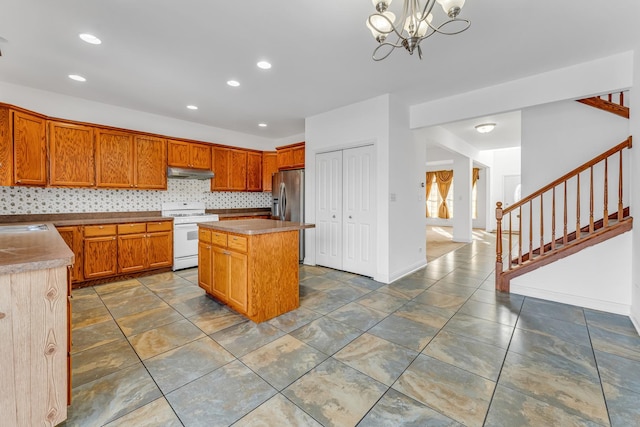 kitchen with stainless steel refrigerator with ice dispenser, decorative light fixtures, a center island, decorative backsplash, and white range oven