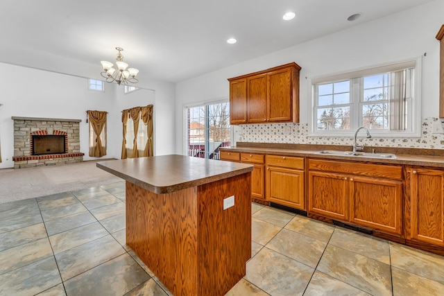 kitchen featuring light tile patterned flooring, a kitchen island, sink, backsplash, and a chandelier