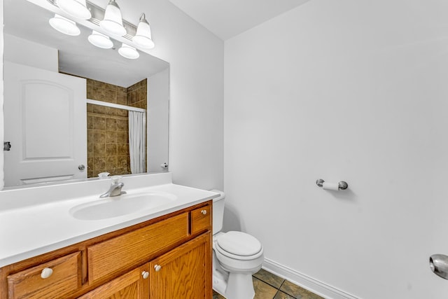 bathroom with vanity, toilet, tile patterned flooring, and a tile shower