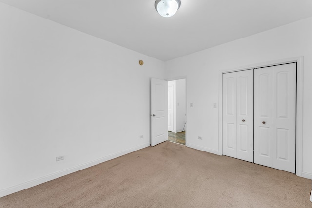 unfurnished bedroom featuring a closet and light carpet