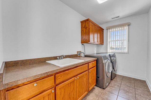 washroom featuring sink, cabinets, washing machine and clothes dryer, and light tile patterned flooring