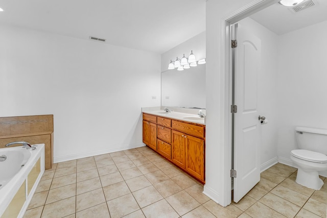 bathroom with vanity, tile patterned floors, tiled bath, and toilet