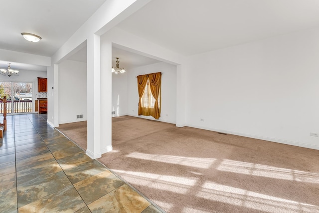 unfurnished room featuring a chandelier and dark carpet