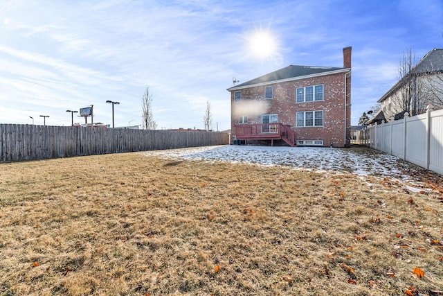 back of property with a wooden deck and a lawn