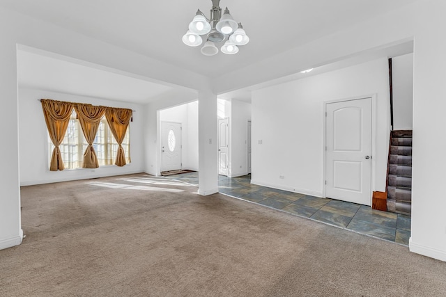 unfurnished living room featuring an inviting chandelier and dark carpet