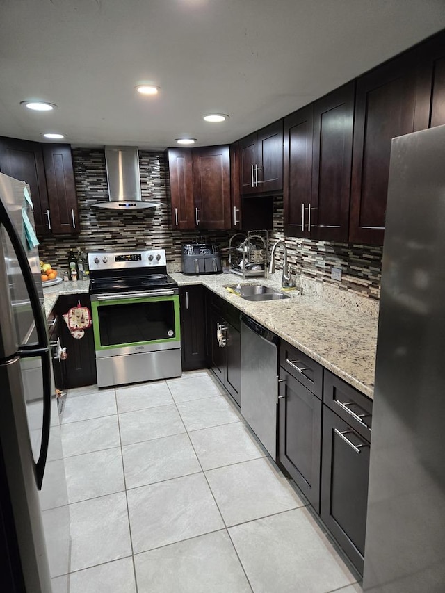 kitchen with wall chimney range hood, sink, dark brown cabinets, light tile patterned flooring, and stainless steel appliances