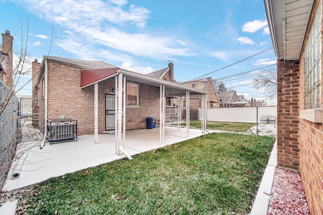 rear view of house with a yard and a patio