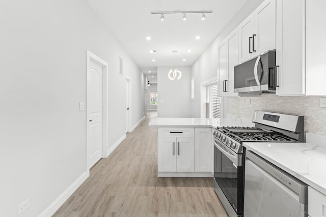 kitchen featuring light stone countertops, appliances with stainless steel finishes, backsplash, light hardwood / wood-style flooring, and white cabinets