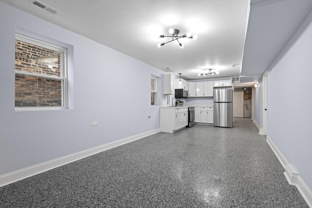 kitchen with a chandelier, appliances with stainless steel finishes, and white cabinetry