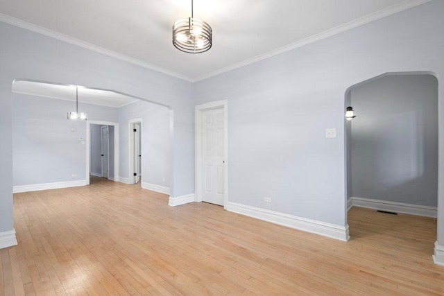 empty room with light wood-type flooring, an inviting chandelier, and ornamental molding