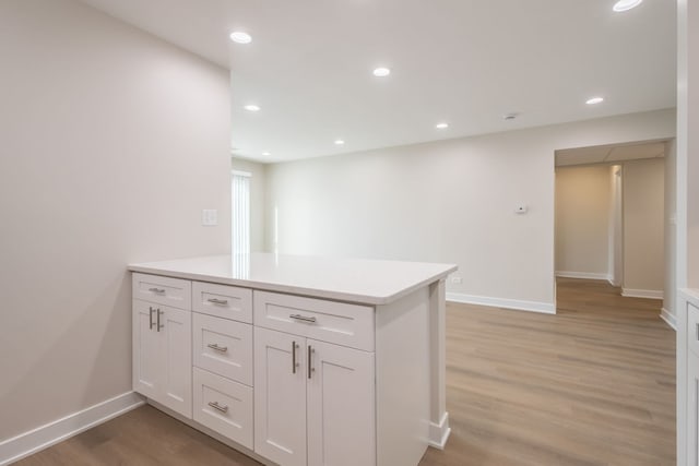 kitchen with white cabinetry and light hardwood / wood-style flooring