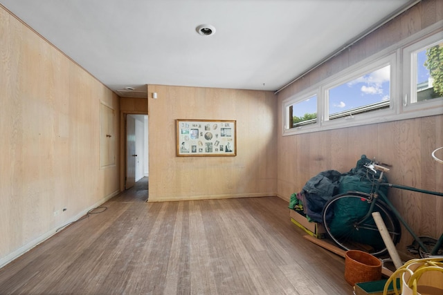 spare room featuring light wood-type flooring and wood walls