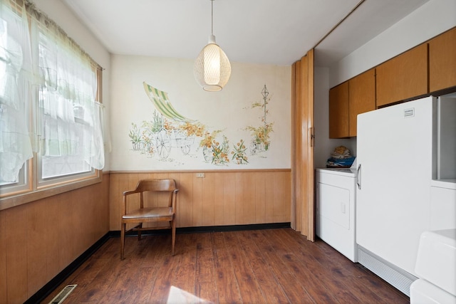 interior space featuring wood walls, dark hardwood / wood-style flooring, and washer / clothes dryer