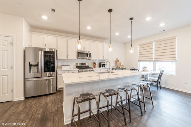 kitchen featuring white cabinets, decorative light fixtures, and stainless steel appliances