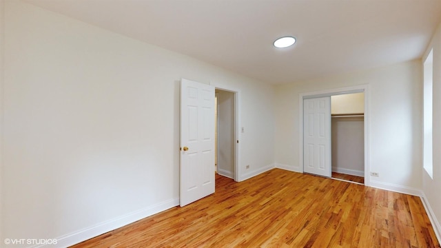 unfurnished bedroom with light wood-type flooring and a closet