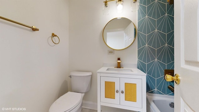 bathroom with vanity, toilet, and a tub