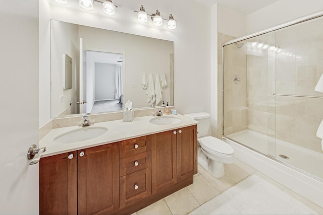 bathroom with toilet, vanity, tile patterned floors, and a shower with shower door