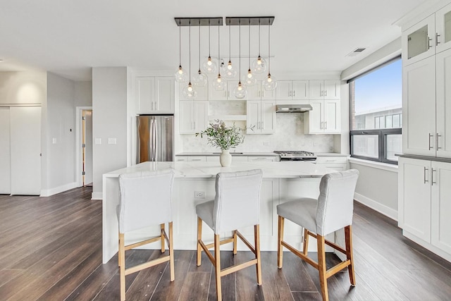 kitchen with appliances with stainless steel finishes, ventilation hood, pendant lighting, a center island, and white cabinetry