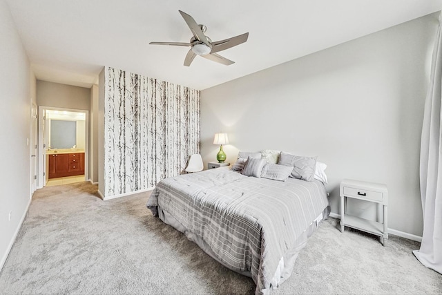 bedroom featuring ceiling fan, light colored carpet, and ensuite bathroom