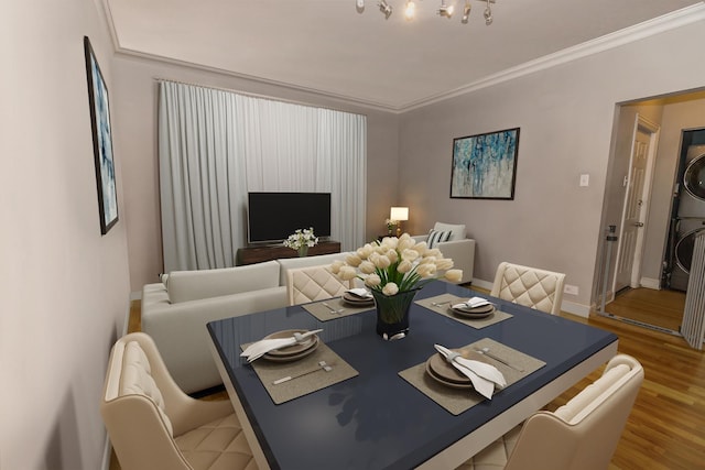 dining space with hardwood / wood-style floors, stacked washing maching and dryer, and ornamental molding