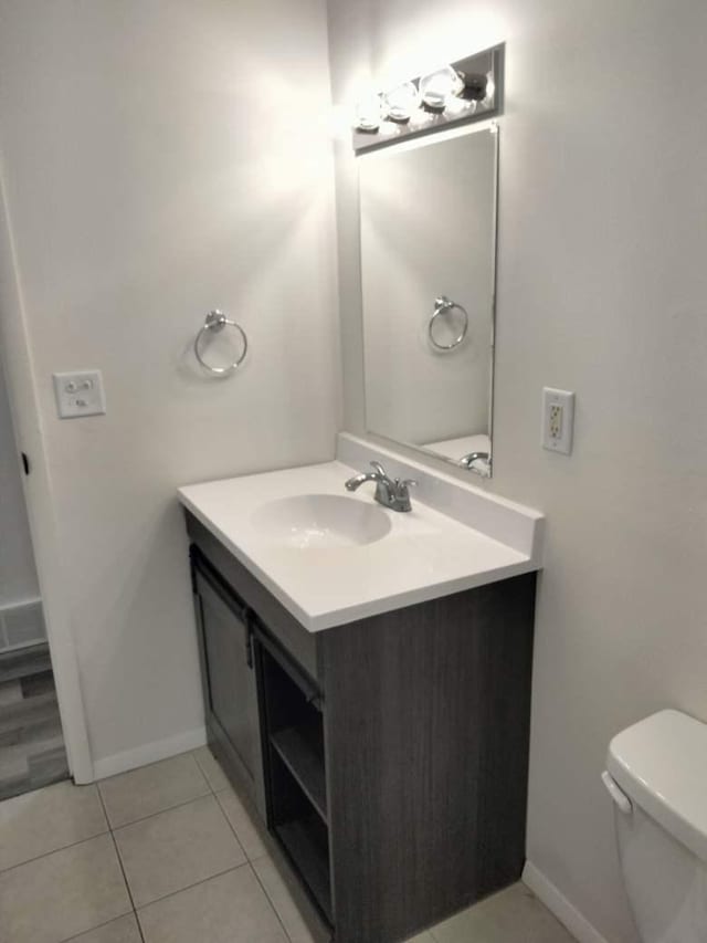 bathroom featuring tile patterned flooring, vanity, and toilet