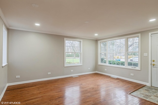 empty room featuring wood-type flooring and crown molding