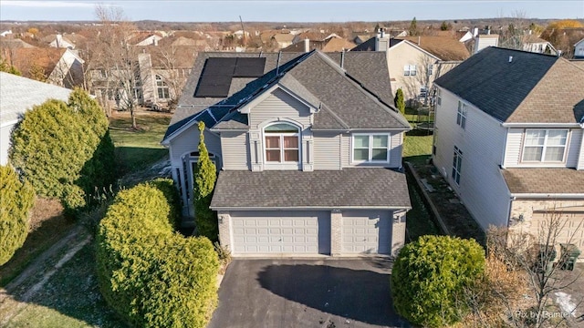 view of front of house featuring solar panels and a garage