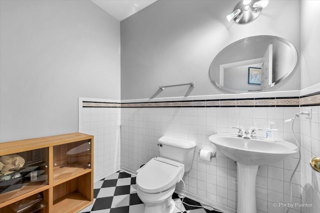 bathroom featuring tile walls and toilet