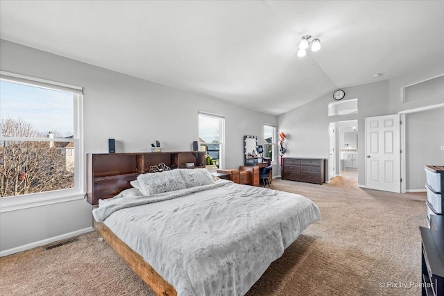 carpeted bedroom with multiple windows and vaulted ceiling