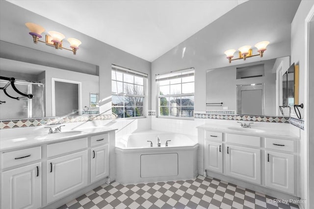 bathroom with tasteful backsplash, vanity, plus walk in shower, and vaulted ceiling