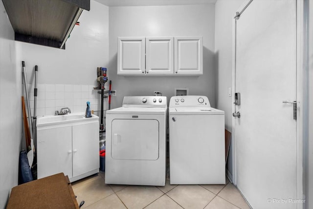 washroom with cabinets, light tile patterned flooring, and washing machine and clothes dryer