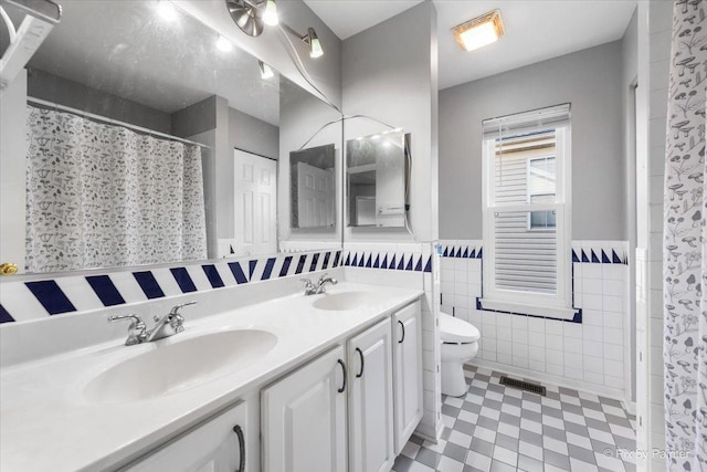 bathroom with vanity, tile walls, curtained shower, and toilet