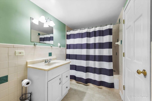 bathroom with tile walls, vanity, curtained shower, and tile patterned floors