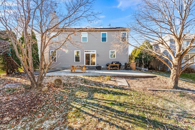 rear view of property with a patio and a lawn