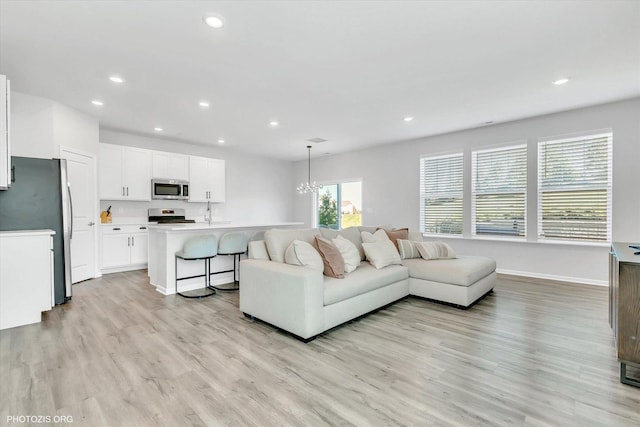 living room with a chandelier and light wood-type flooring