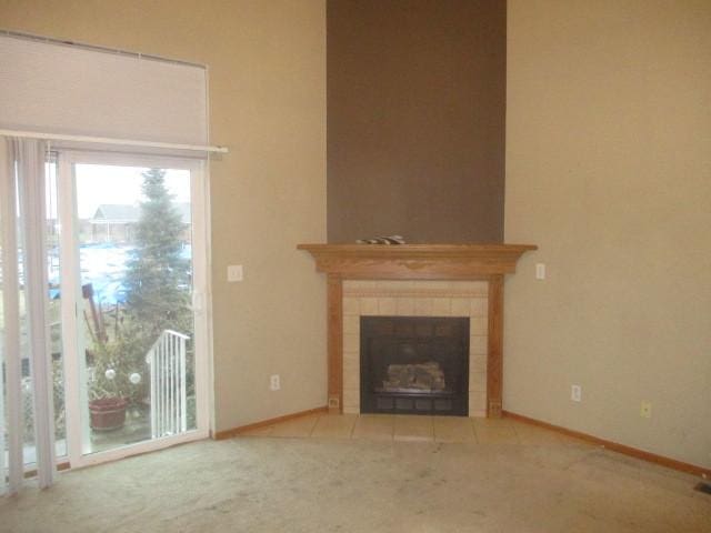 unfurnished living room featuring a tile fireplace and carpet