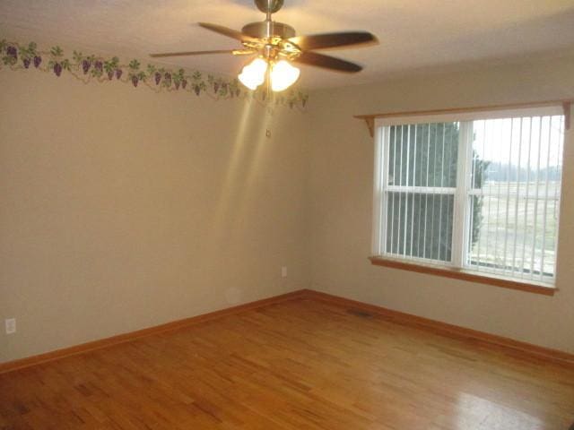 unfurnished room with hardwood / wood-style flooring and ceiling fan