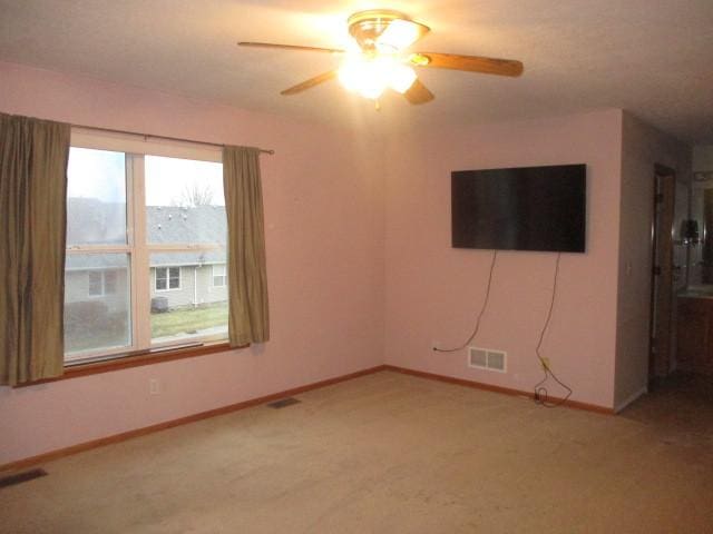 carpeted spare room featuring ceiling fan