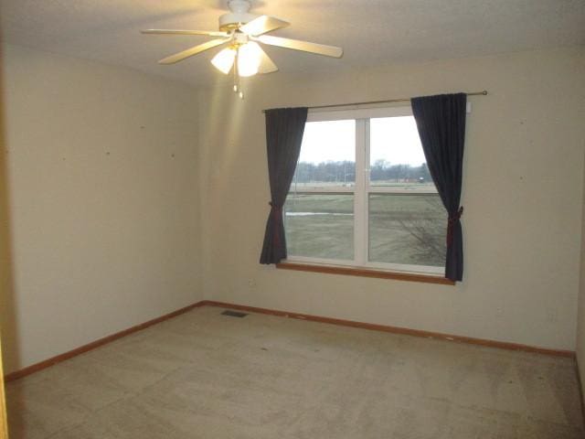 empty room featuring carpet flooring and ceiling fan