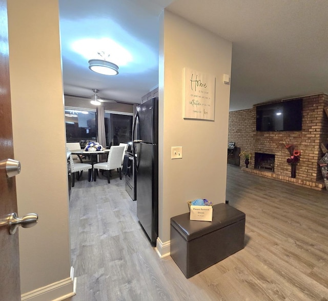 hallway featuring brick wall and wood-type flooring