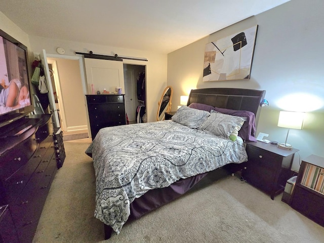 bedroom with carpet and a barn door