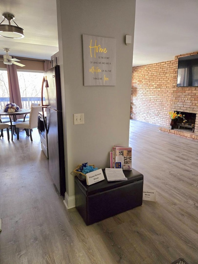 hallway with hardwood / wood-style flooring and brick wall