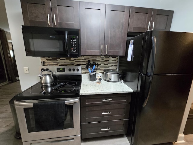 kitchen featuring light stone countertops, tasteful backsplash, dark brown cabinetry, and black appliances