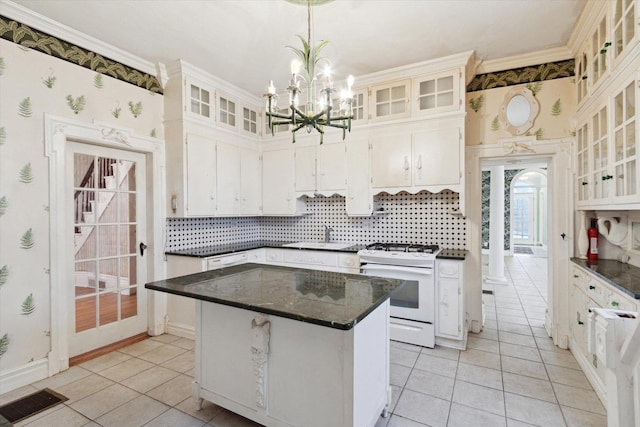 kitchen featuring white range oven, white cabinetry, a center island, and decorative light fixtures