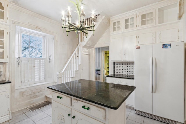 kitchen featuring white cabinets, white fridge, a kitchen island, and light tile patterned floors