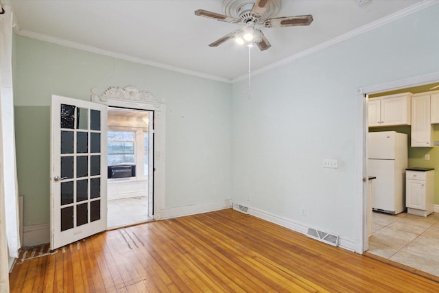 empty room with ceiling fan, light wood-type flooring, and crown molding