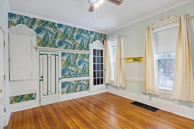 empty room featuring hardwood / wood-style floors, ceiling fan, and ornamental molding